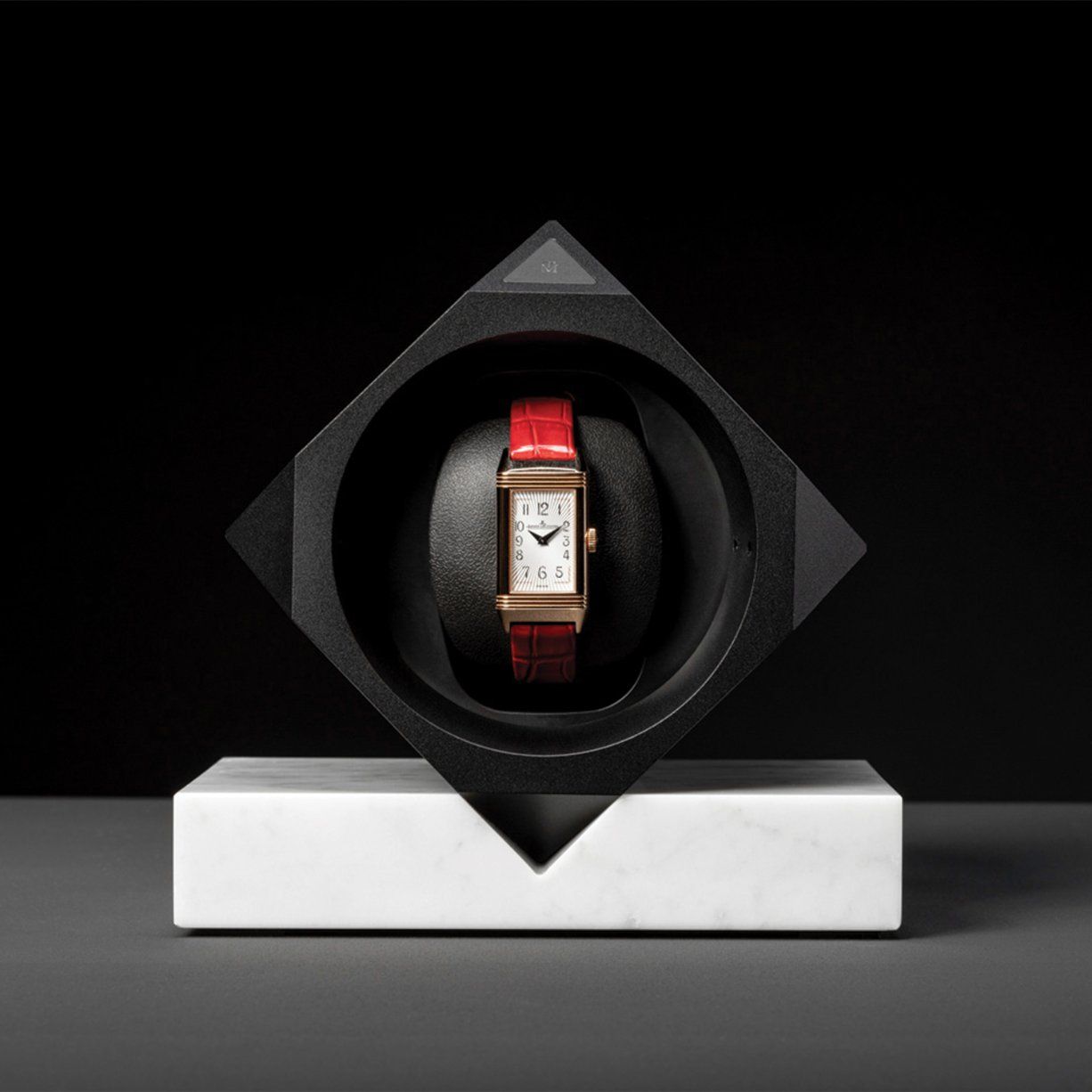 Red-strap watch on a winder, marble base